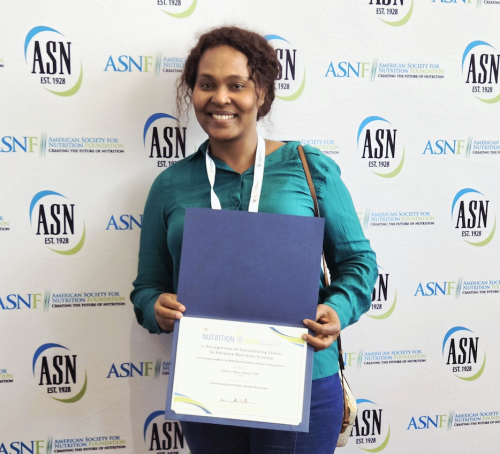 Smiling person holding certificate and blue folder against ASN logo backdrop