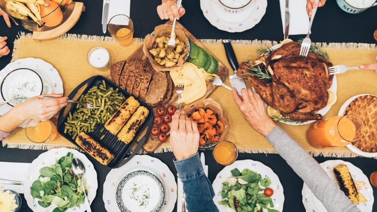 Food on a table with hands reaching across