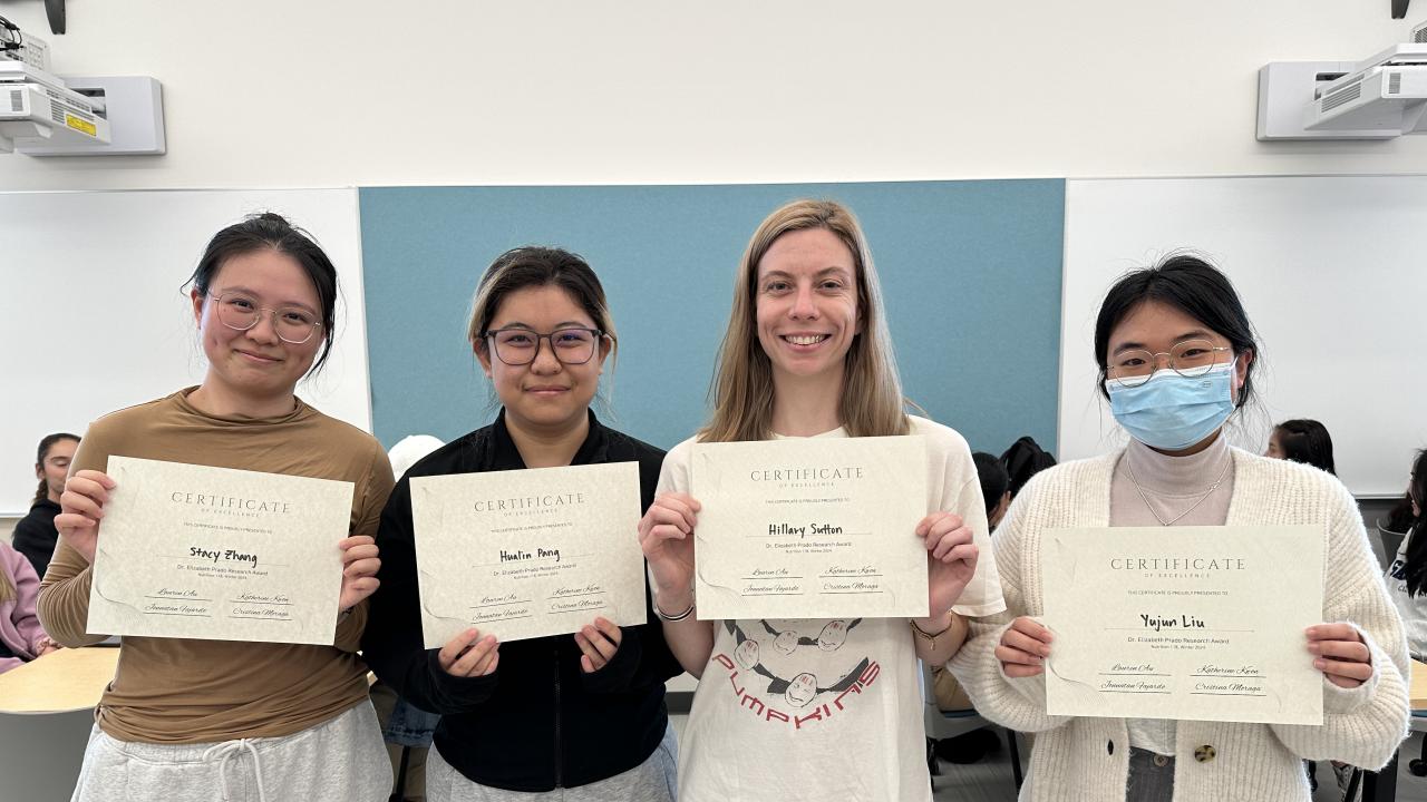 Four students holding up Dr. Elizabeth Prado Research Award certificates