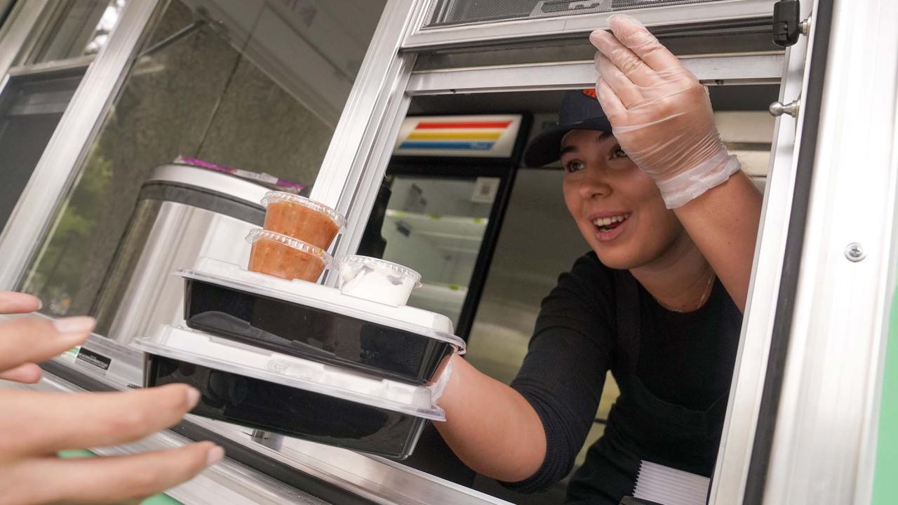 Worker passes out food from AggieEats food truck